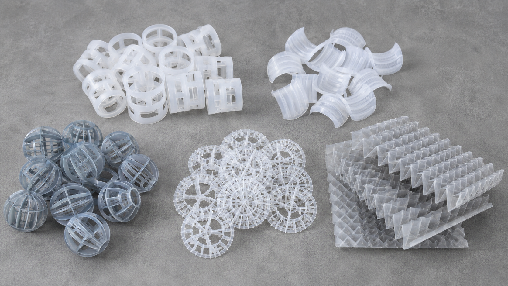 Five types of scrubber packing media: Pall rings, saddle rings, Tri-Packs, Tellerette rings, and structured corrugated sheet packing arranged on a workbench